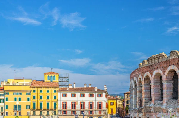 De Verona Arena kalkstenen muren met boogvensters en oude kleurrijke veelkleurige gebouwen — Stockfoto