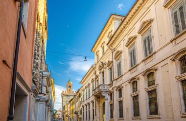 Eski renkli binaları ve Torre della Pallata tuğlalı ortaçağ kulesi olan tipik İtalyan caddesi.