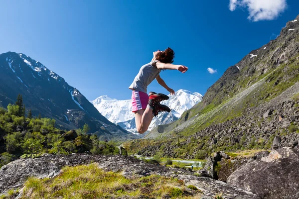 Mujer salta al cielo en lo alto de las montañas de Altai — Foto de Stock