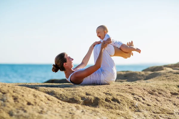 Mère et fils faisant des exercices sur la plage . — Photo