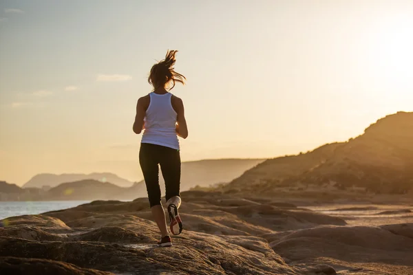 Kaukasisk kvinna jogging på havsstranden — Stockfoto