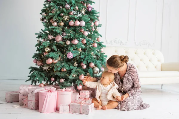 Dítě a matka poblíž vánoční strom — Stock fotografie