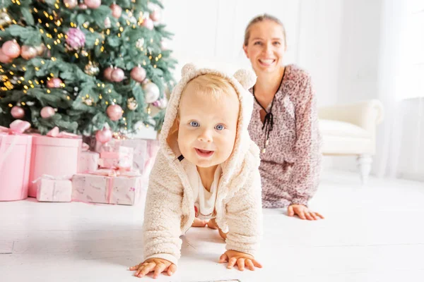 Dítě a matka poblíž vánoční strom — Stock fotografie