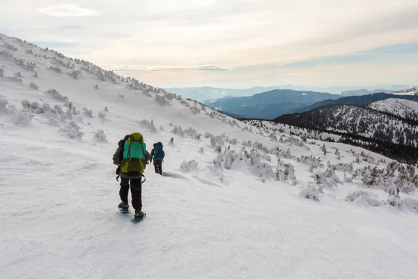 Homem caminhando em montanhas de inverno antes de trovoada — Fotografia de Stock