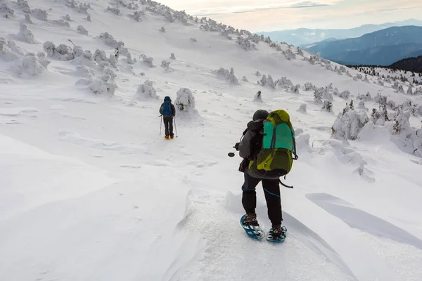 Homem caminhando em montanhas de inverno antes de trovoada — Fotografia de Stock