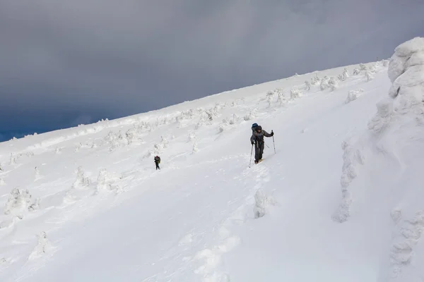 Homem caminhando em montanhas de inverno antes de trovoada — Fotografia de Stock