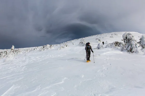 Homme randonnée dans les montagnes d'hiver avant l'orage — Photo