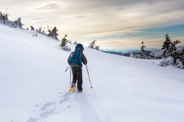Hombre de senderismo en las montañas de invierno antes de tormenta — Foto de Stock