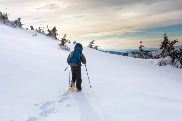 Homem caminhando em montanhas de inverno antes de trovoada — Fotografia de Stock