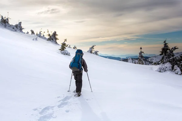 Hombre de senderismo en las montañas de invierno antes de tormenta —  Fotos de Stock