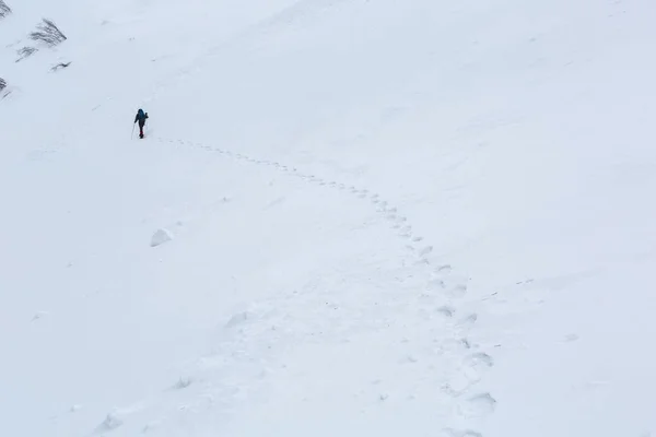 Homem caminhando em montanhas de inverno antes de trovoada — Fotografia de Stock