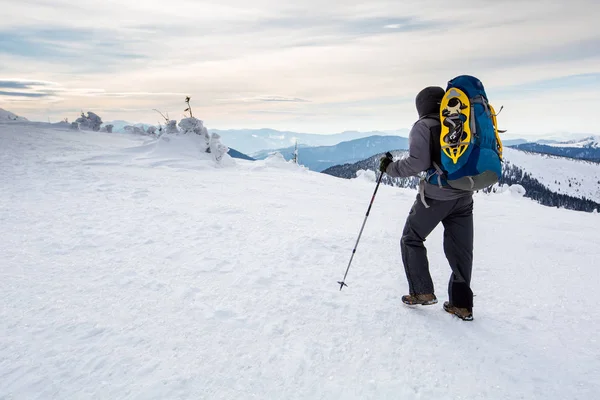 Homem caminhando em montanhas de inverno antes de trovoada — Fotografia de Stock