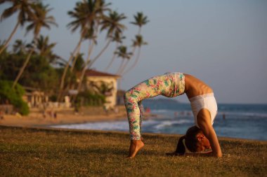 Beyaz kadın, deniz kıyısı: s tropic okyanusun Yoga uygulamak