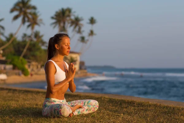 Mujer caucásica practicando yoga en la orilla del océano tropical en s — Foto de Stock