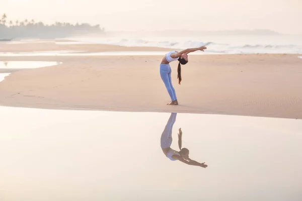 Wanita kaukasia berlatih yoga di pantai samudera tropis — Stok Foto
