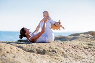 Bir anne ve bir oğlu M deniz kıyısı, yoga egzersizleri yapıyoruz