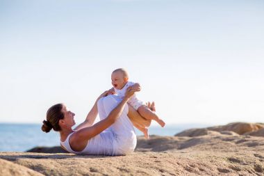 Bir anne ve bir oğlu M deniz kıyısı, yoga egzersizleri yapıyoruz