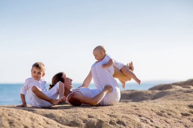 Bir anne ve iki oğlu deniz kıyısı o, yoga egzersizleri yapıyoruz