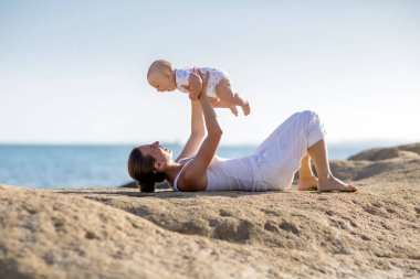 Bir anne ve bir oğlu M deniz kıyısı, yoga egzersizleri yapıyoruz