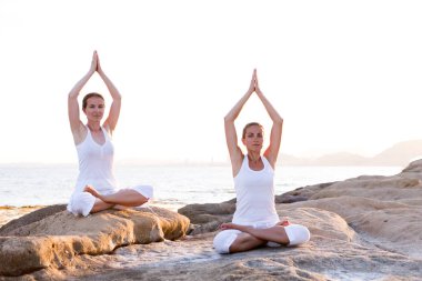 İki kız kardeş Mediterr sahil, yoga egzersizleri yapıyoruz