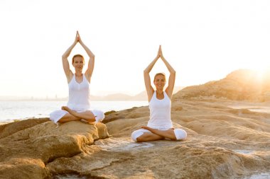 İki kız kardeş Mediterr sahil, yoga egzersizleri yapıyoruz
