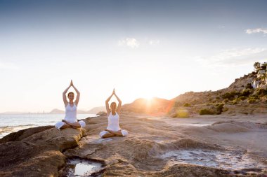 İki kız kardeş Mediterr sahil, yoga egzersizleri yapıyoruz