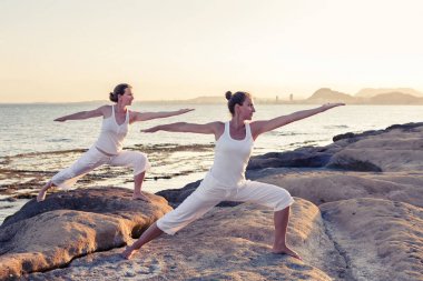 İki kız kardeş Mediterr sahil, yoga egzersizleri yapıyoruz