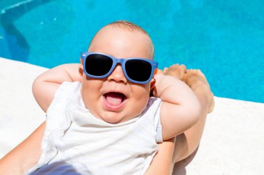 Bir erkek çocuk annesi ile mavi havuzda eğlenir 