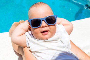 Bir erkek çocuk annesi ile mavi havuzda eğlenir 