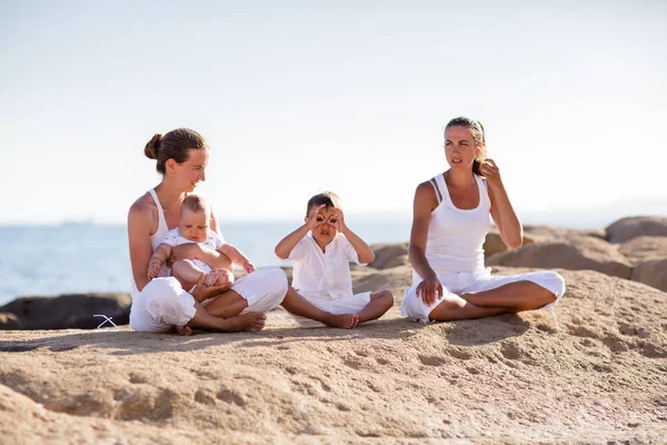 Les mères et leurs fils font des exercices de yoga au bord de la mer — Photo