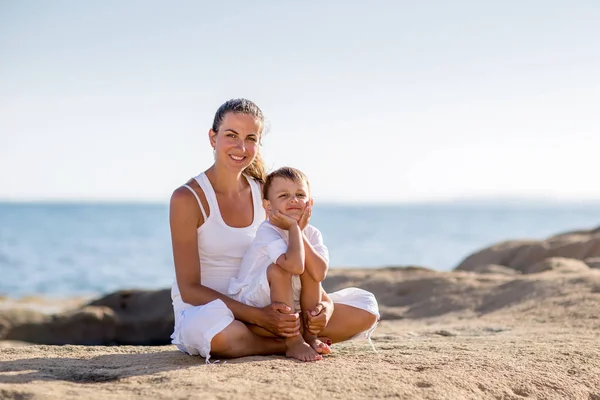 Matka i syn są robi ćwiczenia jogi, nad brzegiem morza M — Zdjęcie stockowe