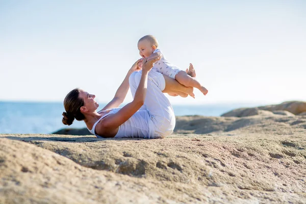 Bir anne ve bir oğlu M deniz kıyısı, yoga egzersizleri yapıyoruz