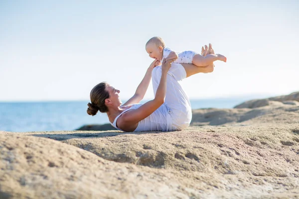 Une mère et un fils font des exercices de yoga au bord de la mer de M — Photo