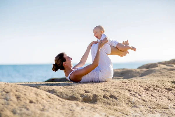 Une mère et un fils font des exercices de yoga au bord de la mer de M — Photo