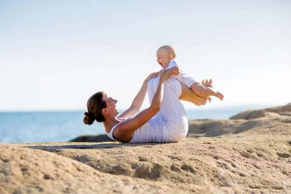 Une mère et un fils font des exercices de yoga au bord de la mer de M — Photo