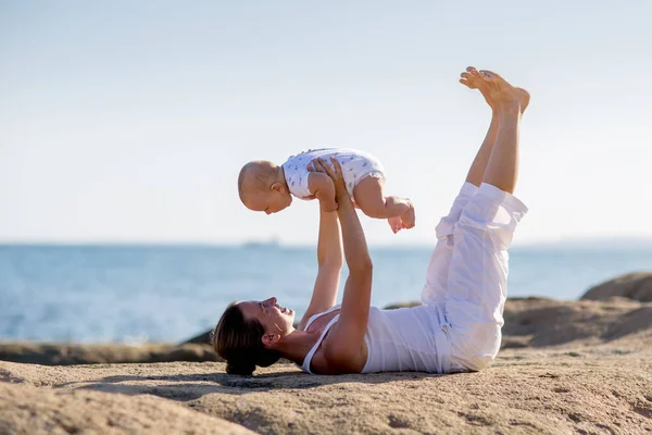 Une mère et un fils font des exercices de yoga au bord de la mer de M — Photo