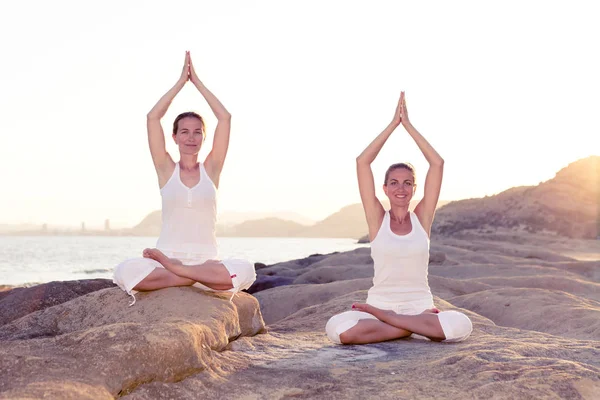 İki kız kardeş Mediterr sahil, yoga egzersizleri yapıyoruz