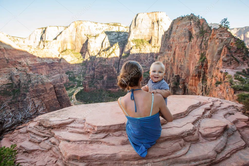 A woman with her baby boy are trekking in Zion national park, Ut