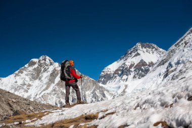 Trekker CIn dağ Khumbu Vadisi'nde bir yolda yaklaşıyor