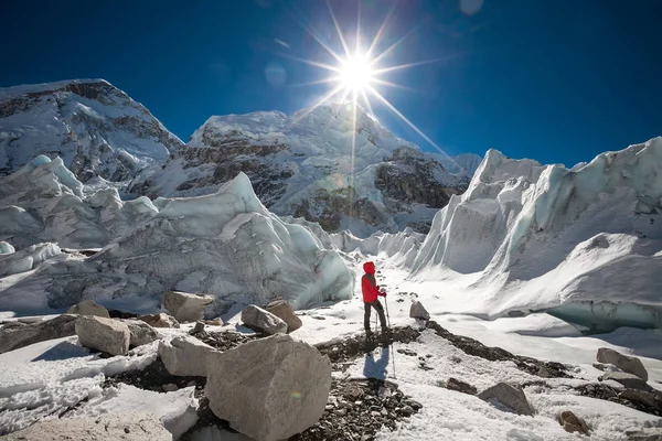 Trekkes está posando frente a la cámara frente a un enorme glaciar cayendo — Foto de Stock