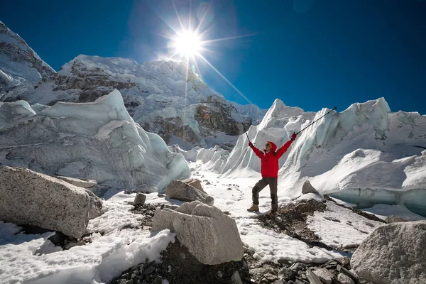 Треккес позирует перед камерой перед огромным падающим ледником — стоковое фото