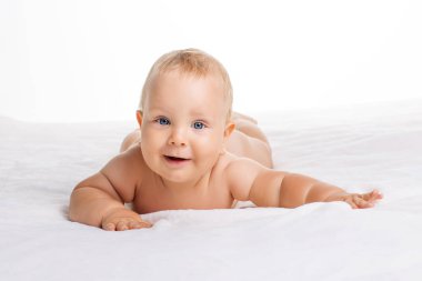 Sevimli gülümseyen bebek havlu üzerinde beyaz izole yatan