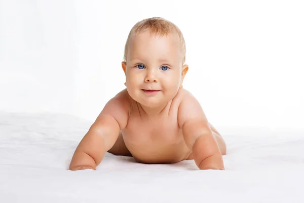 Cute smiling baby lying on towel isolated on white — Stock Photo, Image