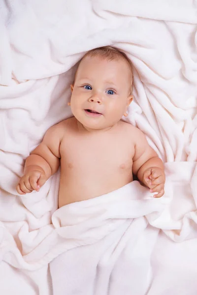 Sevimli gülümseyen bebek banyo sonra havlu altında — Stok fotoğraf