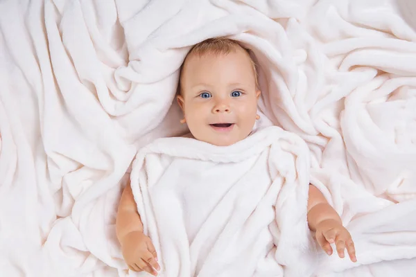Carino bambino sorridente sotto l'asciugamano dopo il bagno — Foto Stock