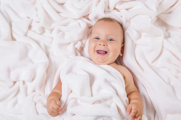 Carino bambino sorridente sotto l'asciugamano dopo il bagno — Foto Stock