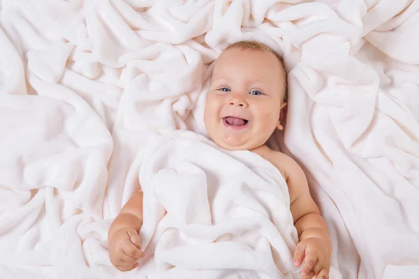 Manis tersenyum bayi di bawah handuk setelah mandi — Stok Foto