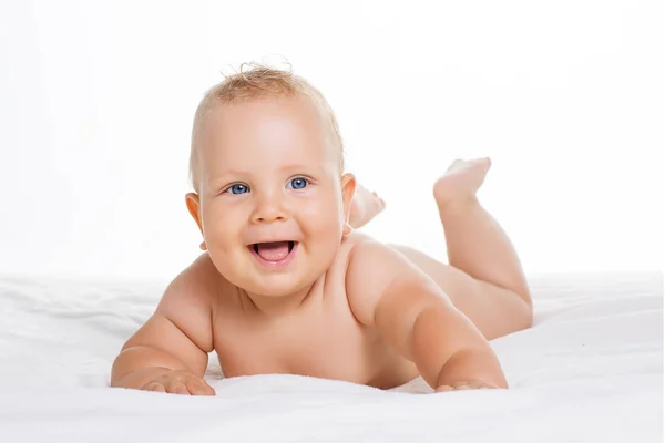 Carino sorridente bambino sdraiato su asciugamano isolato su bianco — Foto Stock