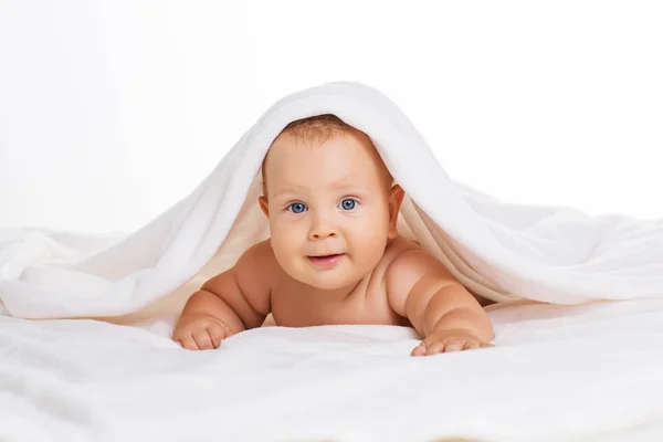 Schattige lachende baby onder handdoek na bad — Stockfoto