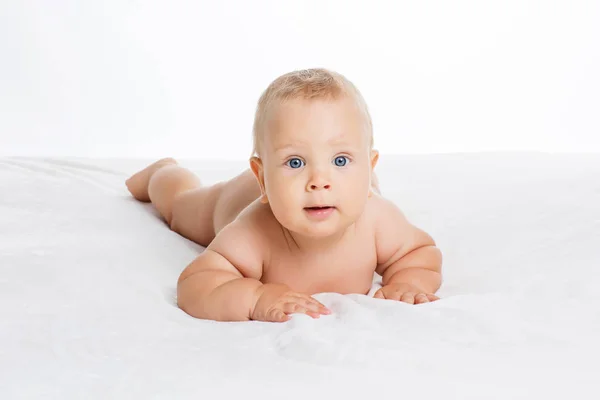 Bonito bebê sorridente deitado em toalha isolada em branco — Fotografia de Stock